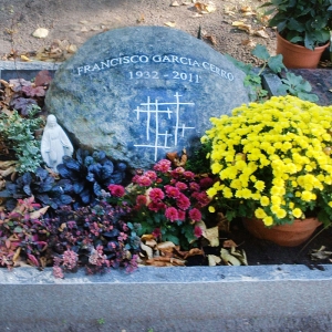 Dunkler Grabstein mit Blumenschmuck