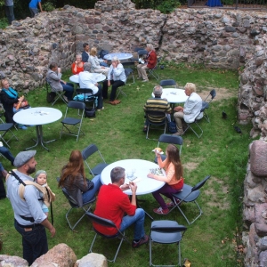 Blick auf restaurierte Burgruine bei der Einweihung mit Menschen an Tischen