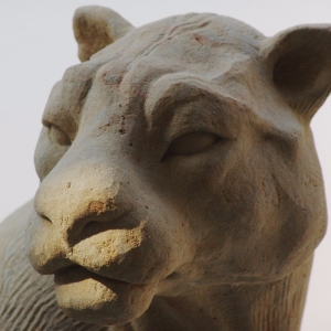 Skulptur aus Sandstein  in Form eines sitzenden Jaguars Nahaufnahme Kopf