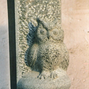 Skulptur als Stele aus grauem Quarzit in Form einer Eule