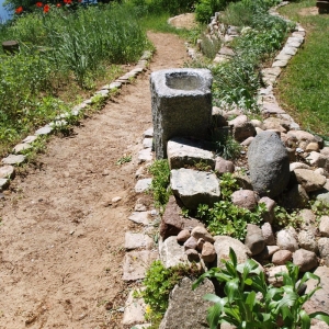 Wasserbecken aus Granit in Form einer rechteckigen Stele in einem Garten