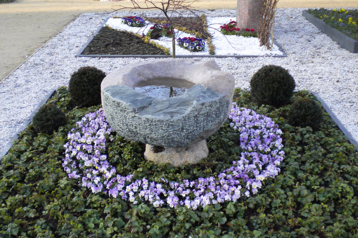 Grabstein in Form eines drehbaren Beckens und Wasserschale aus zwei Findlingen