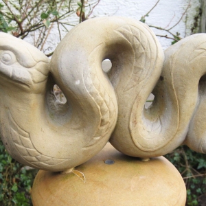 Quellstele aus hellem Sandstein in Form einer Schlange