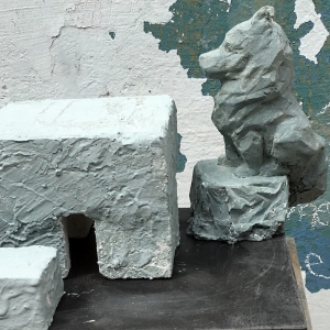 Wolf sitzt mit am Steintisch Modell für Märkische Findlinge, Skulpturen am Usedomradweg